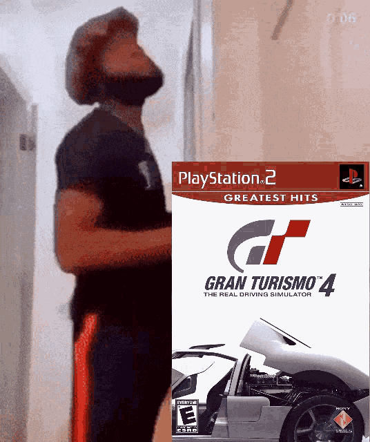 a man standing next to a playstation 2 greatest hits gran turismo 4 game