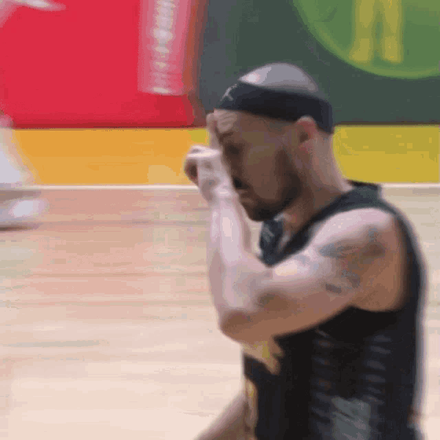 a basketball player with a headband on wipes his face