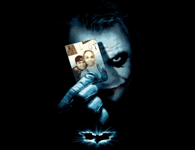 joker holding a card with a picture of a man and a woman on it