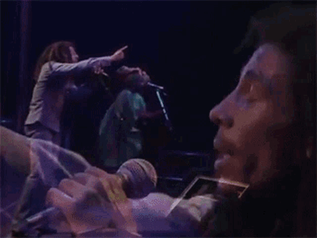 a man singing into a microphone while another man tries to stop him
