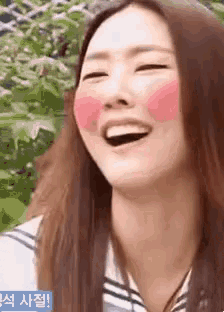 a close up of a woman laughing with a pink blush on her cheeks