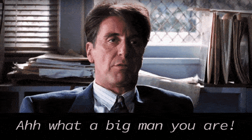 a man in a suit and tie says " ahh what a big man you are " while sitting in front of a window
