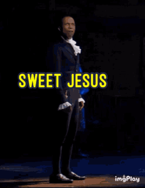 a man in a suit stands on a stage with the words sweet jesus above him