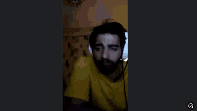 a man wearing headphones and a yellow shirt is on a video call
