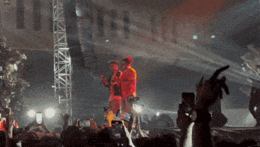 a man in a red shirt is singing into a microphone