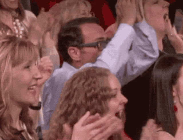 a group of people are sitting in a stadium applauding .