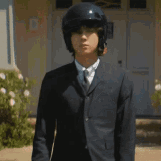 a man in a suit and helmet is waving