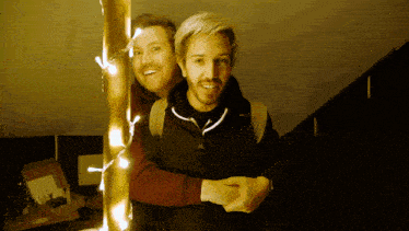 two men are standing next to each other and one has a backpack