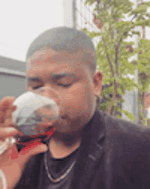 a man is drinking a glass of red wine .