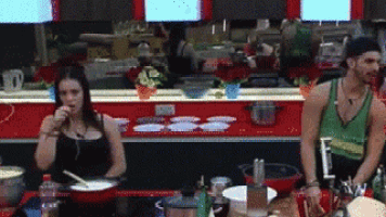 a man and woman are sitting at a table in a kitchen