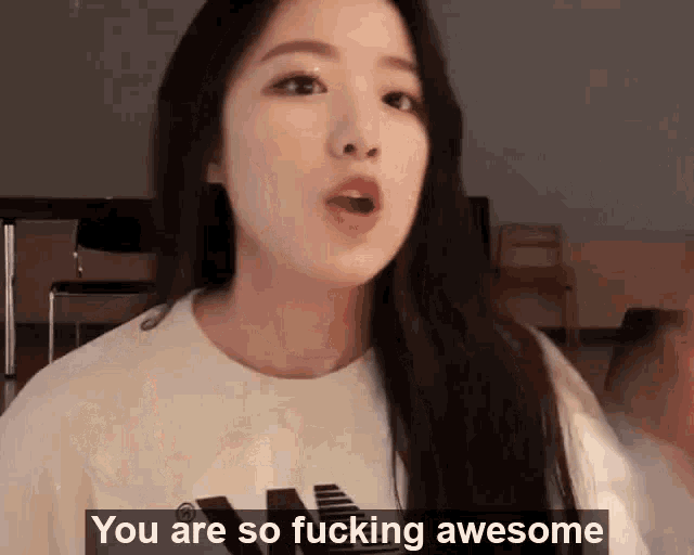 a woman in a white t-shirt is saying you are so fucking awesome