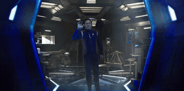 a man is standing in a dark room with a blue light coming out of his hand
