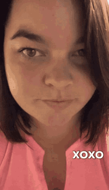a woman in a pink shirt says xoxo on the bottom right