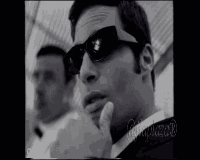 a black and white photo of a man wearing sunglasses with the word cralfer below him