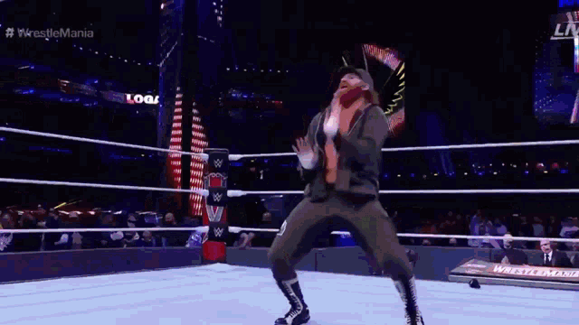 a wrestler is dancing in a wrestling ring during a wrestlemania event .