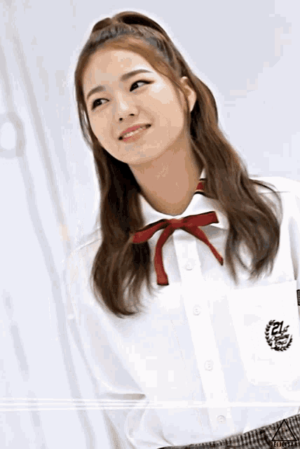 a girl wearing a white shirt with a red bow has the number 21 on her chest