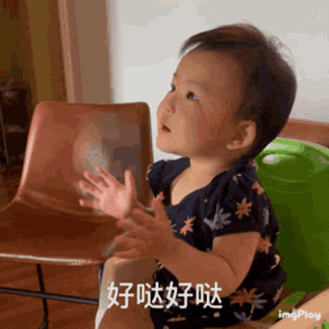 a baby is sitting in a chair with his hands outstretched in a gif that says imgplay