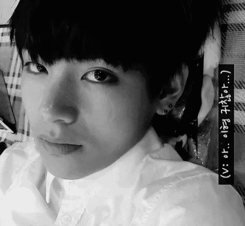 a black and white photo of a young man with foreign writing on the bottom right