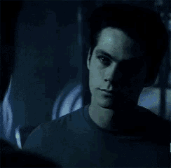 a man is holding another man 's head in a dark room in a blurry photo .