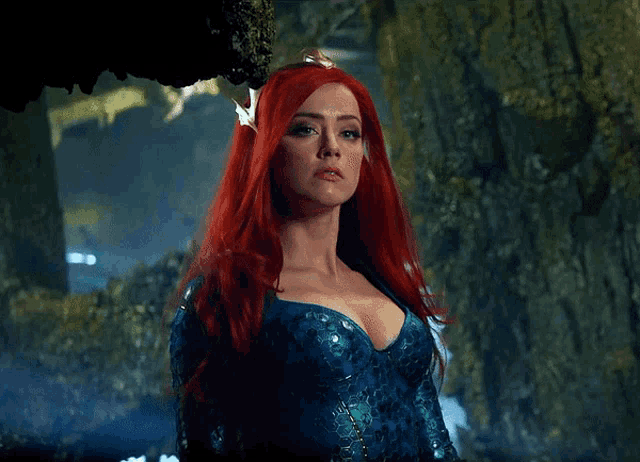 a woman with red hair wearing a blue dress