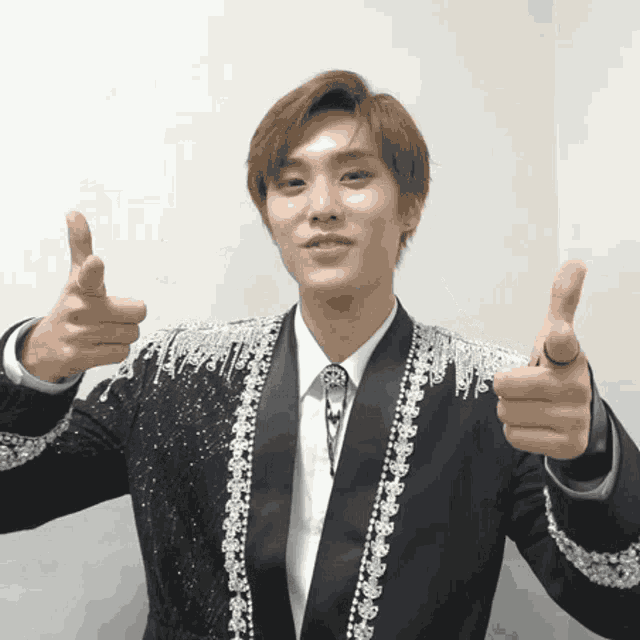 a man in a suit giving a thumbs up