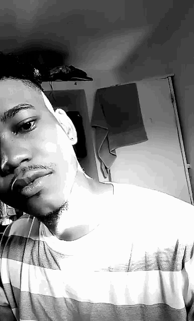 a black and white photo of a man taking a selfie in a room .