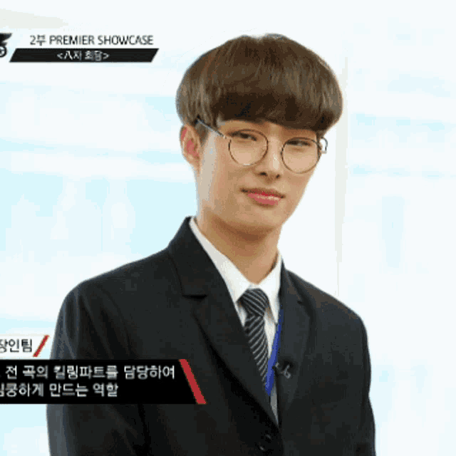 a young man wearing glasses and a suit is in a premier showcase