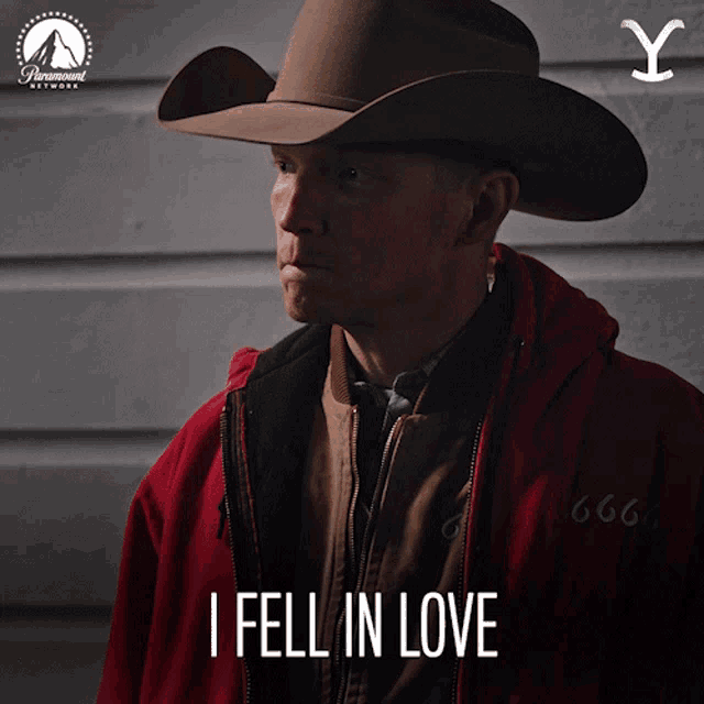 a man wearing a cowboy hat and a red jacket with the words i fell in love