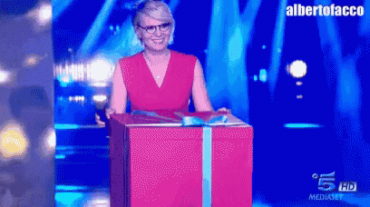 a woman in a red dress is standing in front of a gift box with the words albertofacco on the bottom right