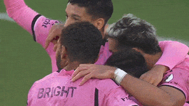 a group of soccer players are huddled together and one of them has the name bright on the back of his jersey
