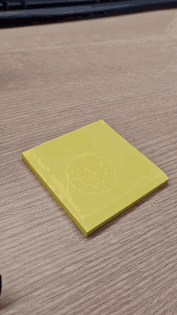a yellow sticky note on a wooden desk