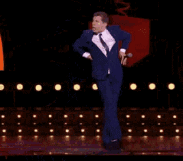 a man in a suit and tie is standing on a stage