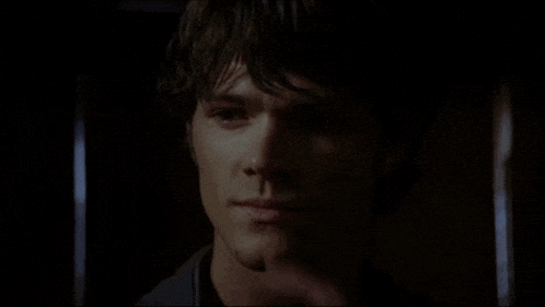 a close up of a man 's face with his finger to his nose