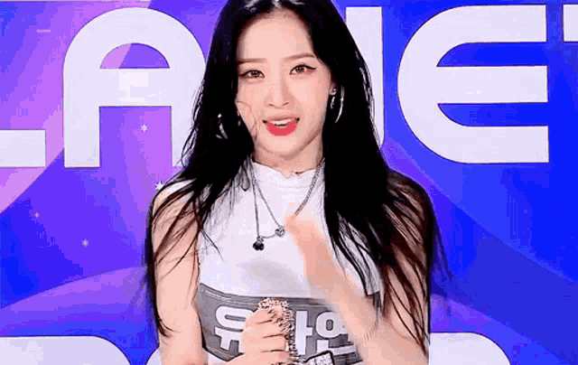 a woman with long black hair is standing in front of a sign that says ' ae '