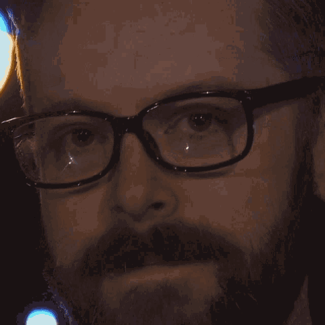 a close up of a man 's face with glasses