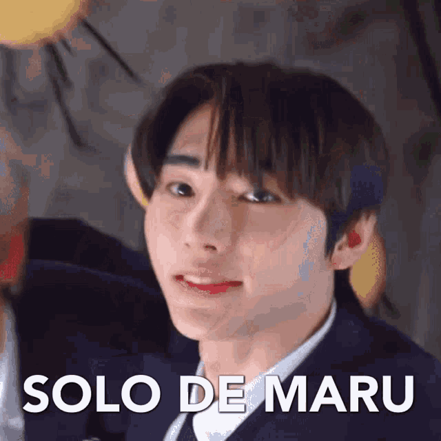 a close up of a young man 's face with the words solo de maru written on it .