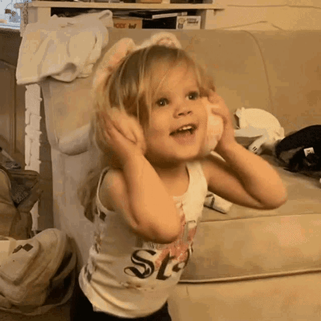 a little girl wearing headphones and a shirt that says st