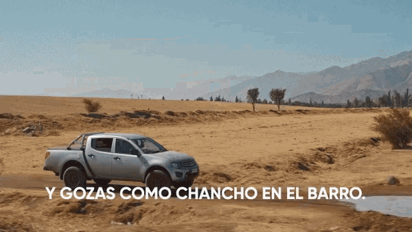 a silver truck is driving through a desert with the words y gozas como chancho en el barro