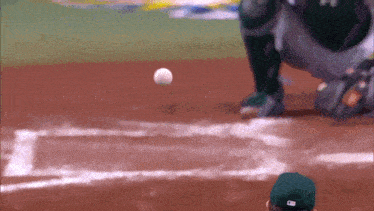 a baseball player in a green hat with the letter m on the back