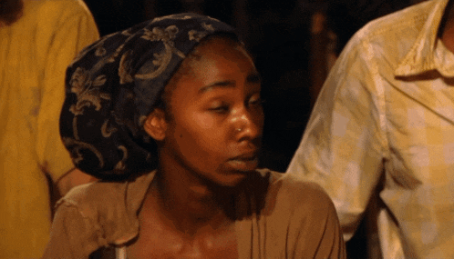 a woman with a head scarf on her head looks down