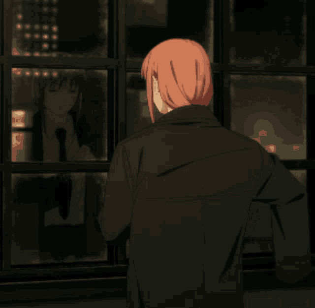 a girl with red hair is looking out a window