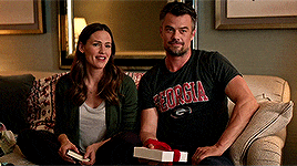 a man wearing a georgia shirt sits next to a woman