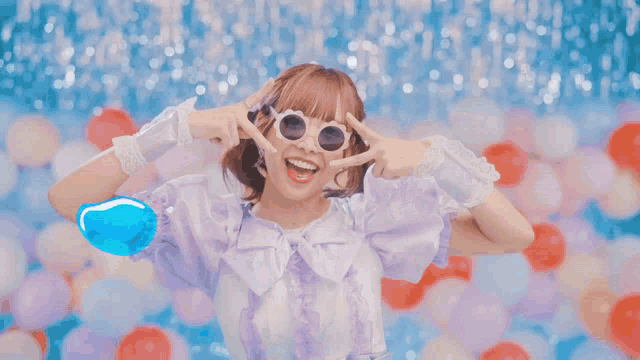 a girl wearing sunglasses and a purple dress is holding a blue object in front of her eyes
