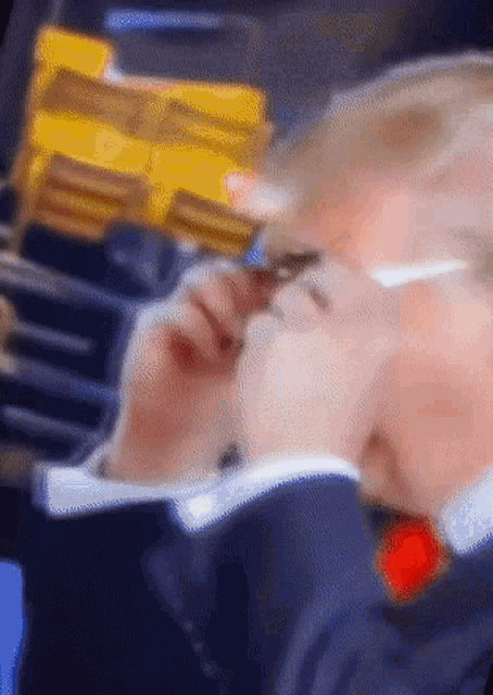 a blurry picture of a man wearing glasses and a red tie