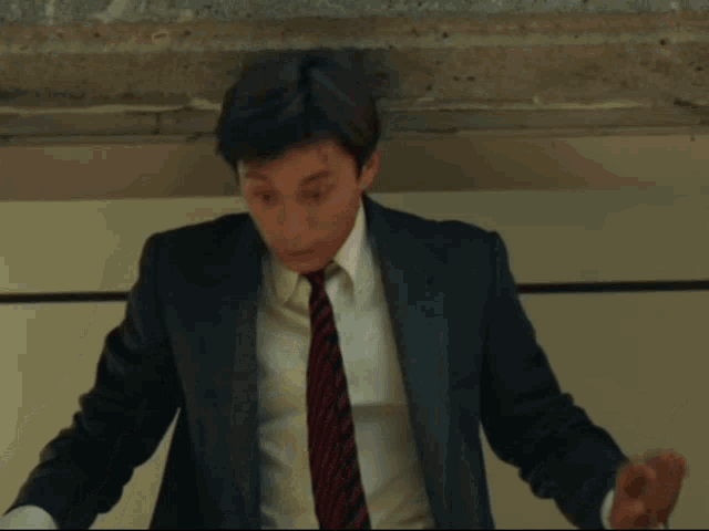 a man in a suit and tie looks down