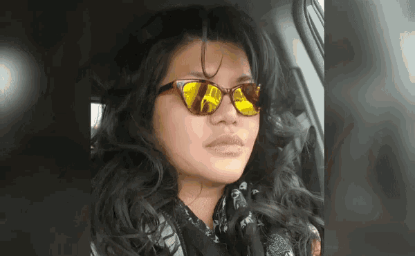 a woman wearing yellow sunglasses is sitting in the back seat of a car
