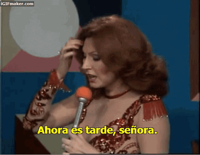 a woman speaking into a microphone with the words ahora es tarde señora