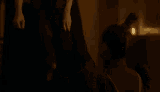 a woman is talking to another woman in a dark room and the woman is saying surprise bitch .