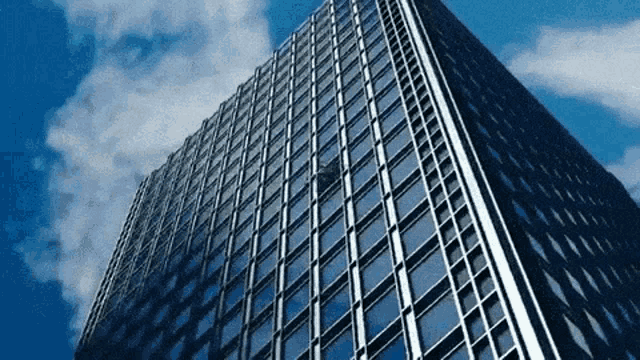 looking up at a skyscraper with a blue sky in the background