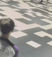a person is standing on a checkered floor and looking at the camera .
